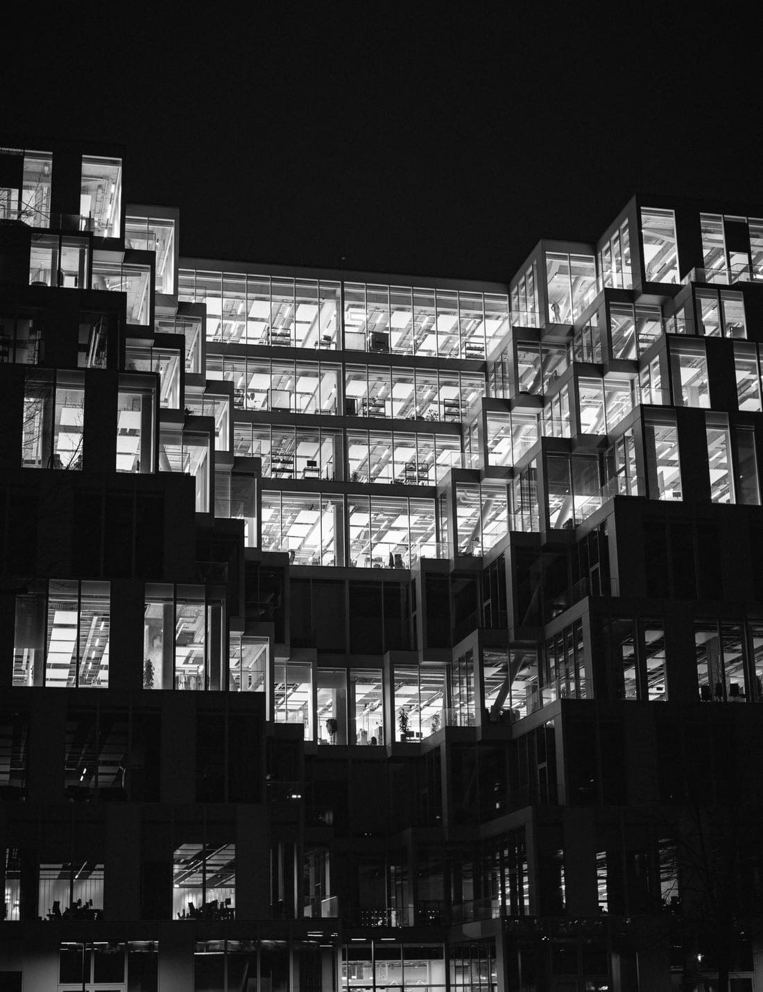 Beleuchtete Büroetagen eines modernen Gebäudes in Berlin bei Nacht